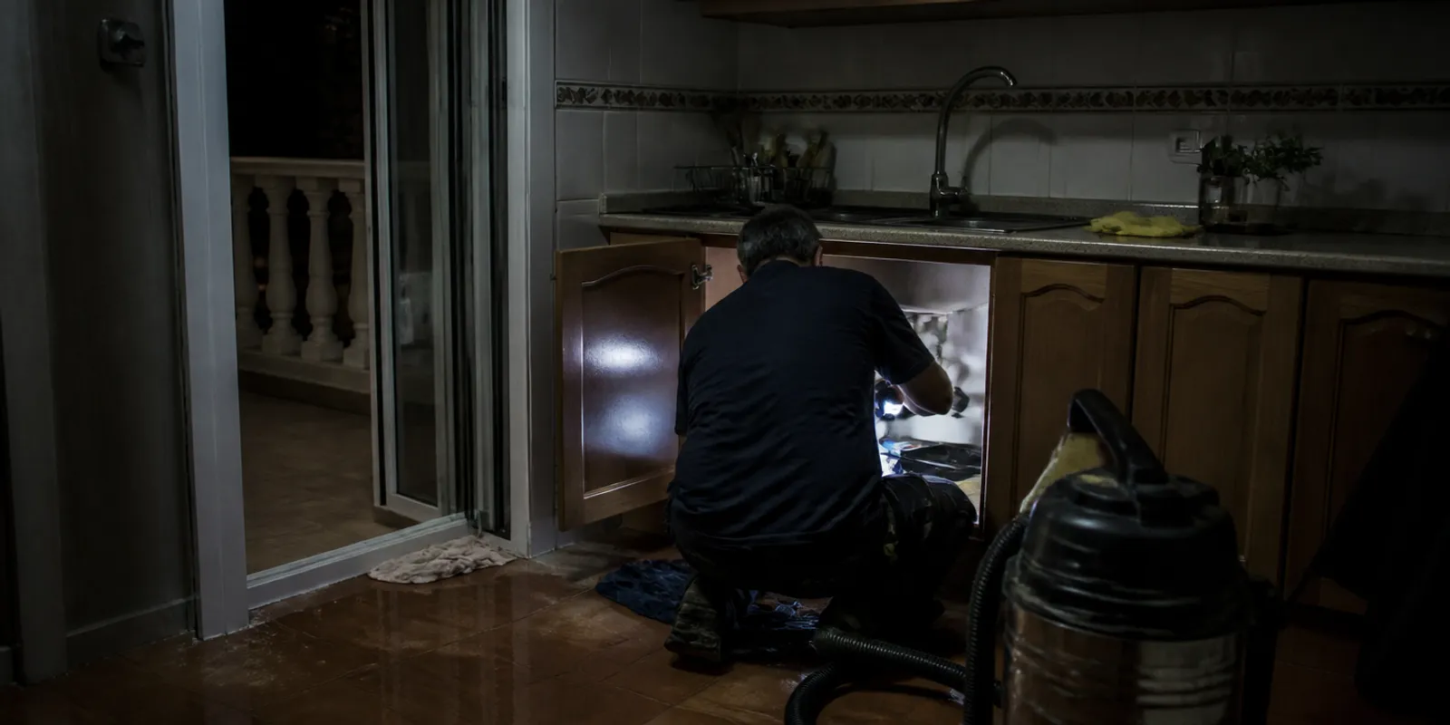 Fontanero de urgencia en Cartagena interviniendo de noche en una cocina inundada